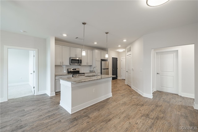 10530 Stony Bluff Dr Unit 305, Ashland, VA 23005 - kitchen featuring appliances with stainless steel finishes, a sink, light wood finished floors, a center island with sink, and recessed lighting