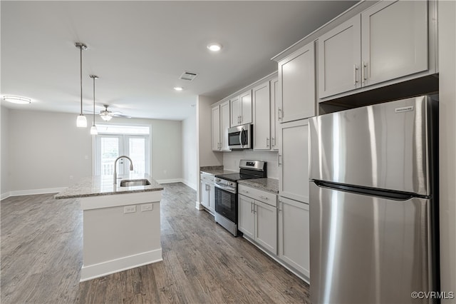 10530 Stony Bluff Dr Unit 305, Ashland, VA 23005 - kitchen featuring appliances with stainless steel finishes, a sink, baseboards, an island with sink, and wood finished floors