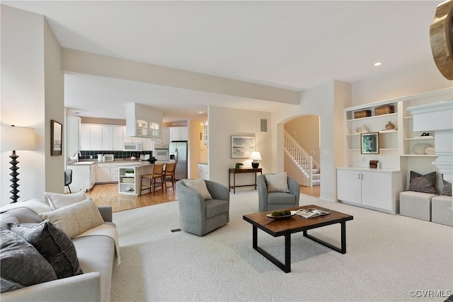 8831 Whistling Swan Rd, Chesterfield, VA 23838 - living area with arched walkways, light wood-type flooring, recessed lighting, light colored carpet, and stairway