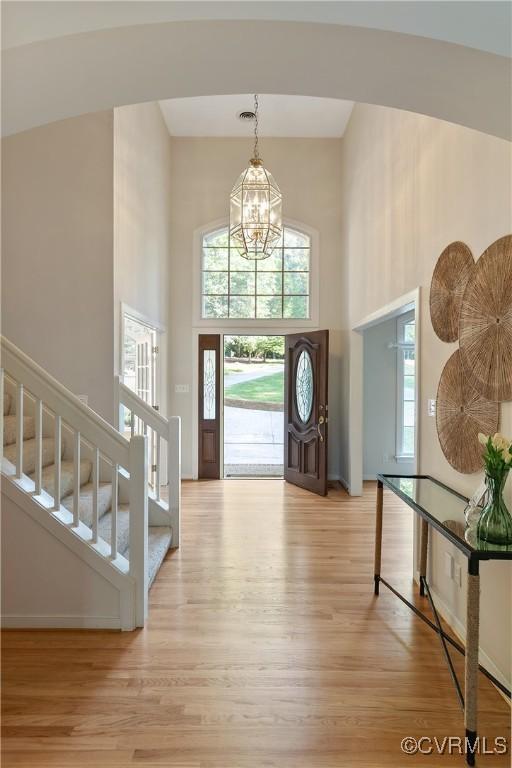 8831 Whistling Swan Rd, Chesterfield, VA 23838 - foyer featuring a high ceiling, a chandelier, light wood-style flooring, plenty of natural light, and stairway