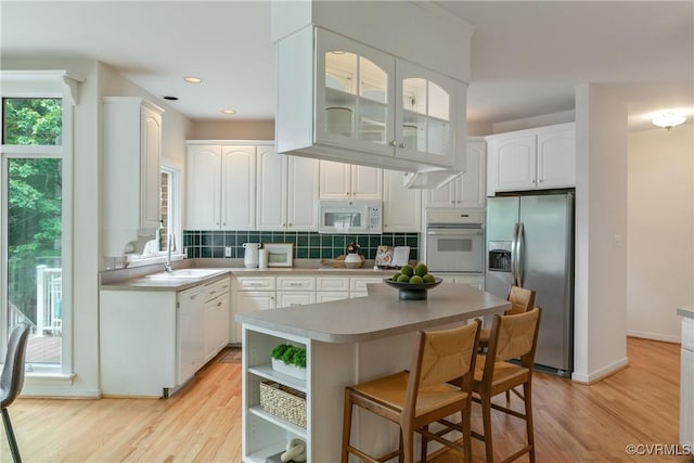 8831 Whistling Swan Rd, Chesterfield, VA 23838 - kitchen featuring white appliances, a sink, white cabinetry, light wood-style floors, and recessed lighting