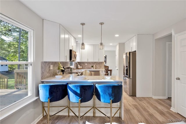 11202 Heathstead Rd, Chester, VA 23831 - kitchen with stainless steel appliances, backsplash, light countertops, light wood-type flooring, and a peninsula