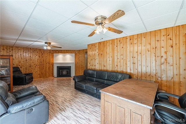 17063 Moores Mill Rd, Ruther Glen, VA 22546 - living room with a ceiling fan, wood walls, wood finished floors, a fireplace, and a drop ceiling