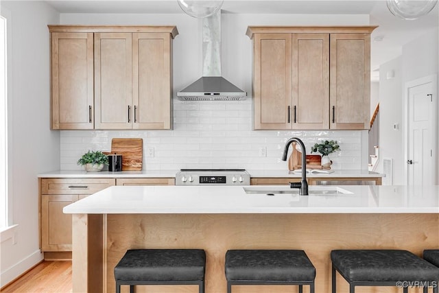 2207 Fairmount Ave, Richmond, VA 23223 - kitchen featuring wall chimney exhaust hood, a kitchen breakfast bar, range, and tasteful backsplash