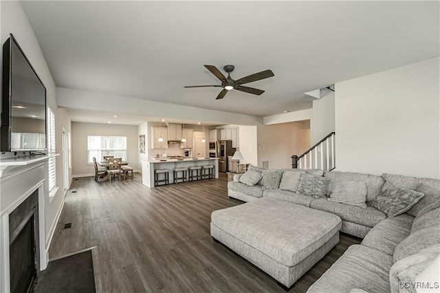 18160 Sagamore Dr, Chesterfield, VA 23120 - living room featuring ceiling fan, dark wood-style flooring, a fireplace with flush hearth, stairs, and baseboards