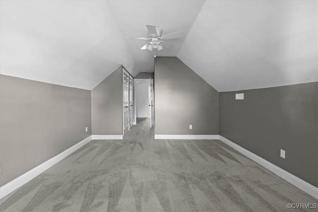 additional living space featuring a ceiling fan, carpet floors, vaulted ceiling, and baseboards