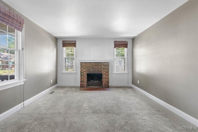 unfurnished living room with carpet, a fireplace, and baseboards