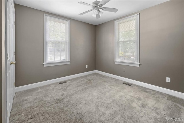 spare room with carpet floors, a ceiling fan, and baseboards