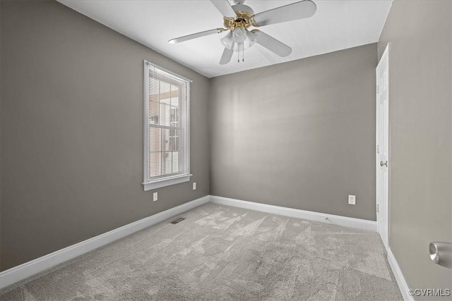 carpeted empty room featuring ceiling fan and baseboards