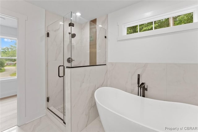 107 Wheeley Cir, Yorktown, VA 23693 - bathroom with marble tiled floors, tile walls, a marble finish shower, and a freestanding tub