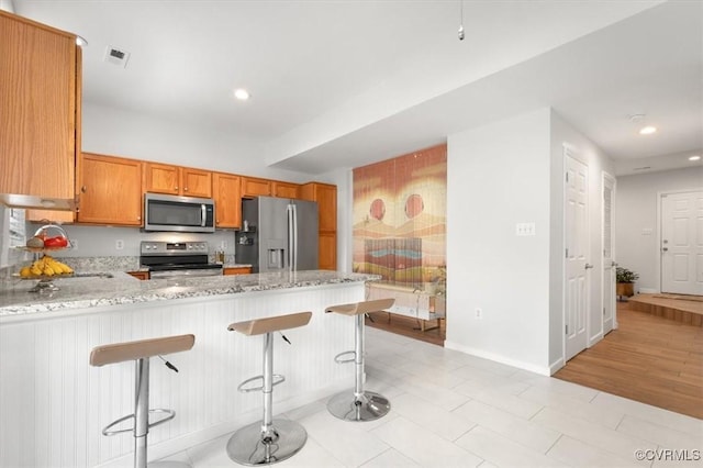 2603 Mountainberry Ct, Glen Allen, VA 23060 - kitchen featuring appliances with stainless steel finishes, light stone counters, recessed lighting, a peninsula, and baseboards