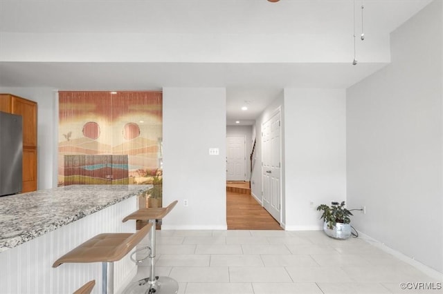 2603 Mountainberry Ct, Glen Allen, VA 23060 - kitchen with freestanding refrigerator, baseboards, recessed lighting, brown cabinetry, and light stone countertops