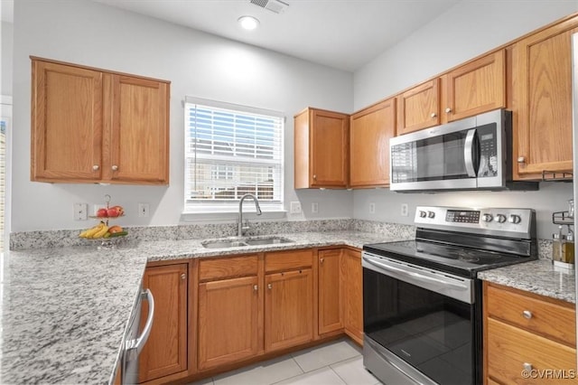 2603 Mountainberry Ct, Glen Allen, VA 23060 - kitchen with appliances with stainless steel finishes, a sink, light stone counters, light tile patterned flooring, and brown cabinetry