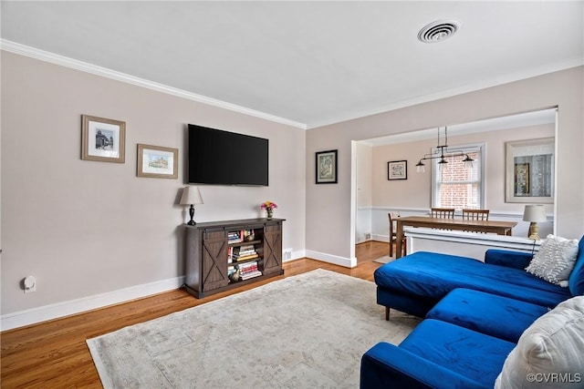 4719 W Grace St, Richmond, VA 23230 - living room featuring a chandelier, ornamental molding, baseboards, and wood finished floors