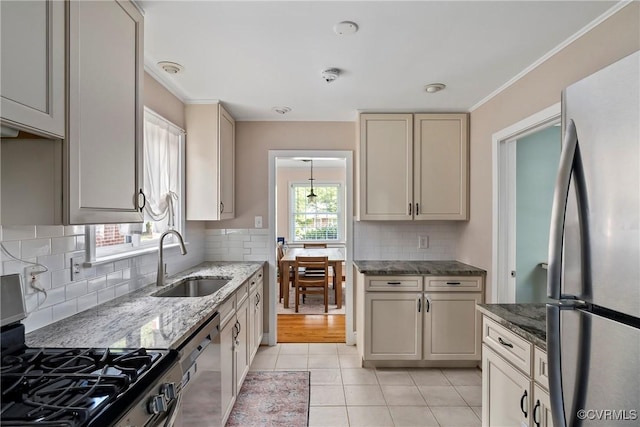4719 W Grace St, Richmond, VA 23230 - kitchen featuring appliances with stainless steel finishes, a sink, light tile patterned floors, light stone counters, and ornamental molding