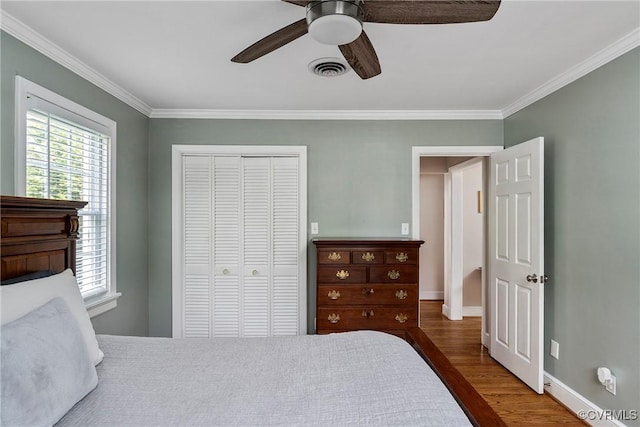 4719 W Grace St, Richmond, VA 23230 - bedroom with wood finished floors, multiple windows, crown molding, a closet, and a ceiling fan