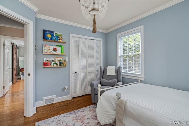 4719 W Grace St, Richmond, VA 23230 - bedroom featuring a chandelier, wood finished floors, ornamental molding, baseboards, and a closet