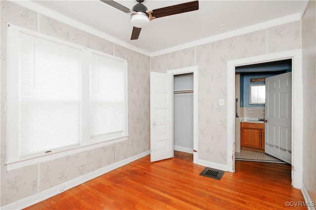400 Allen Ave, Hopewell, VA 23860 - unfurnished bedroom featuring light wood finished floors, baseboards, a closet, a ceiling fan, and wallpapered walls