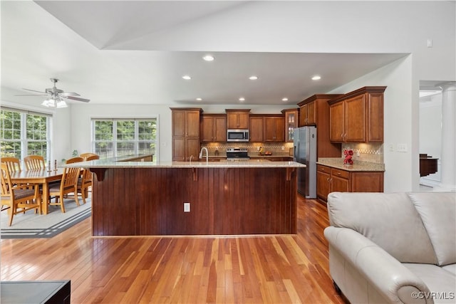 14109 Rigney Dr, Midlothian, VA 23113 - kitchen featuring stainless steel appliances, open floor plan, light wood finished floors, ceiling fan, and brown cabinetry