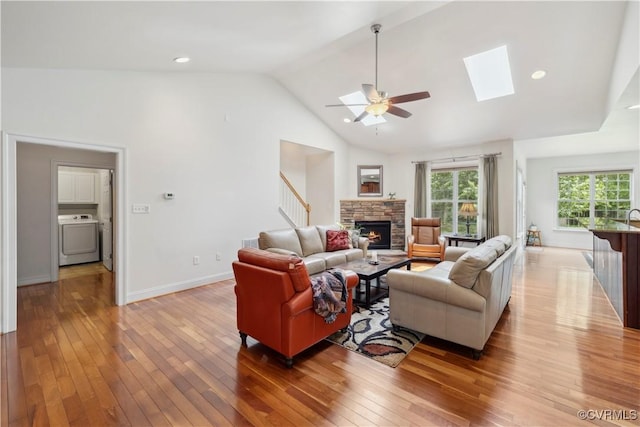14109 Rigney Dr, Midlothian, VA 23113 - living area with washer / dryer, light wood-style floors, ceiling fan, a stone fireplace, and a skylight
