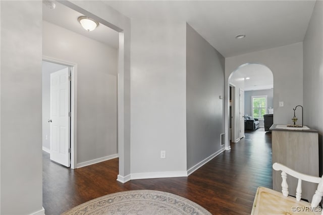 13524 Thomaswoods Ln, Ashland, VA 23005 - corridor featuring dark wood-style floors, arched walkways, and baseboards