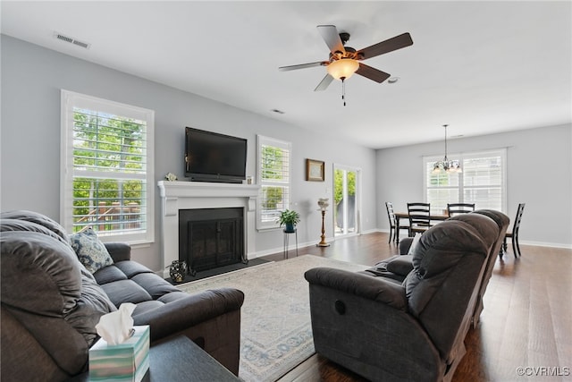 13524 Thomaswoods Ln, Ashland, VA 23005 - living room with dark wood finished floors, ceiling fan, a fireplace with flush hearth, and a chandelier