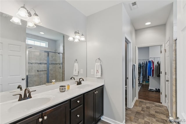 13524 Thomaswoods Ln, Ashland, VA 23005 - bathroom with a stall shower, stone finish flooring, double vanity, a walk in closet, and baseboards