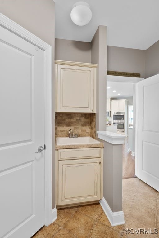 16300 Midnight Xing, Chesterfield, VA 23120 - bar area with light tile patterned floors, tasteful backsplash, stainless steel double oven, and a sink