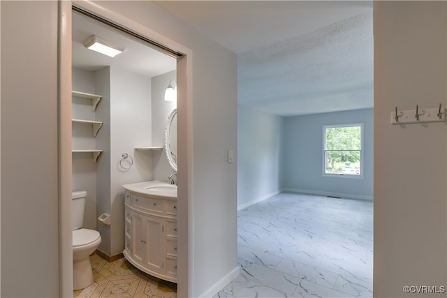 10002 Laurel Lakes Dr, Glen Allen, VA 23060 - bathroom featuring marble finish flooring, toilet, vanity, and baseboards
