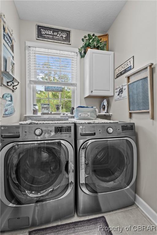 6304 Belroi Rd, Abingdon, VA 23061 - laundry area featuring cabinet space, washing machine and dryer, tile patterned floors, and baseboards