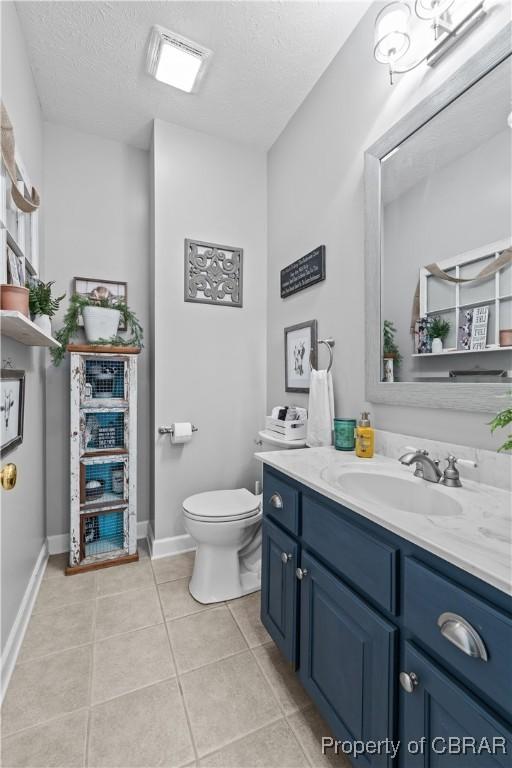 6304 Belroi Rd, Abingdon, VA 23061 - bathroom featuring tile patterned flooring, toilet, vanity, a textured ceiling, and baseboards