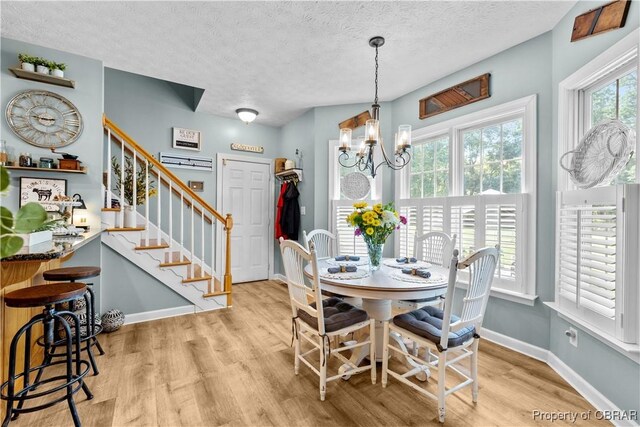6304 Belroi Rd, Abingdon, VA 23061 - dining space with wood finished floors, stairway, a textured ceiling, a chandelier, and baseboards