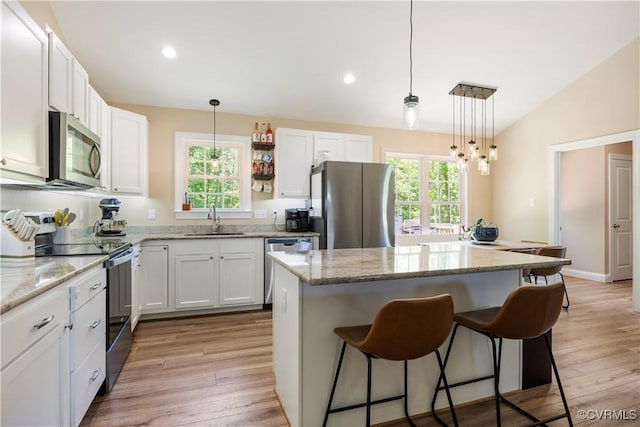 124 Vogel Rd, Cumberland, VA 23040 - kitchen featuring appliances with stainless steel finishes, a sink, a breakfast bar area, a kitchen island, and white cabinetry