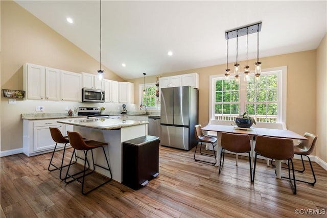 124 Vogel Rd, Cumberland, VA 23040 - kitchen featuring stainless steel appliances, a center island, white cabinets, light wood-style floors, and vaulted ceiling