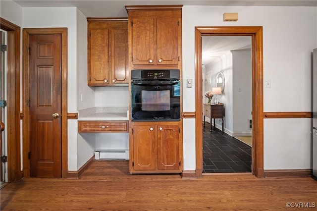 7708 Stonetree Dr, North Chesterfield, VA 23235 - kitchen with black oven, baseboard heating, brown cabinets, and baseboards