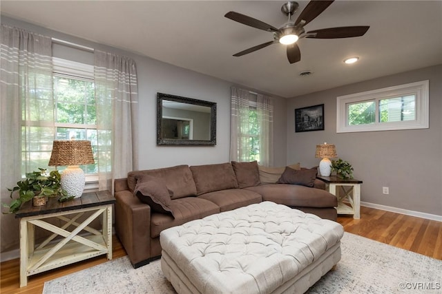 living room with light wood-type flooring, a ceiling fan, baseboards, and recessed lighting