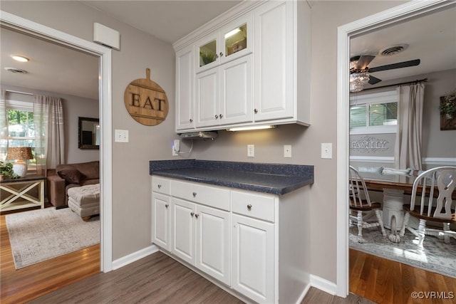 1951 Greenfield Dr, Chesterfield, VA 23235 - kitchen featuring dark wood finished floors, dark countertops, white cabinets, a ceiling fan, and glass insert cabinets