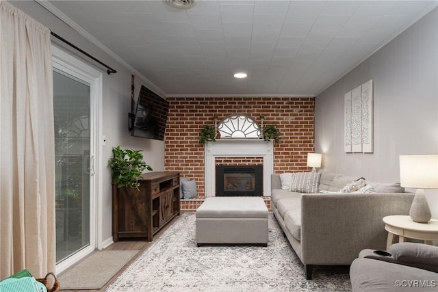 living room featuring ornamental molding, light wood-style flooring, and a fireplace