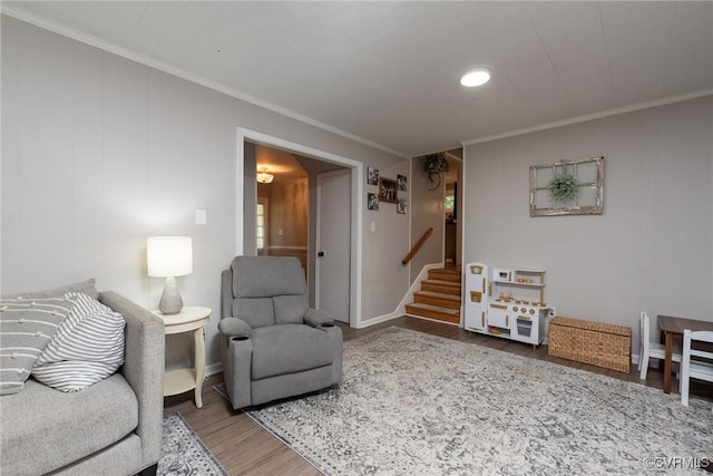 living area with wood finished floors, stairway, ornamental molding, and baseboards