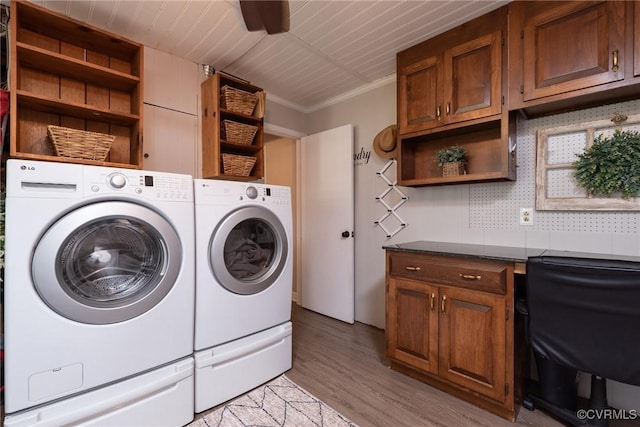 laundry area featuring washing machine and dryer, light wood finished floors, cabinet space, and ornamental molding