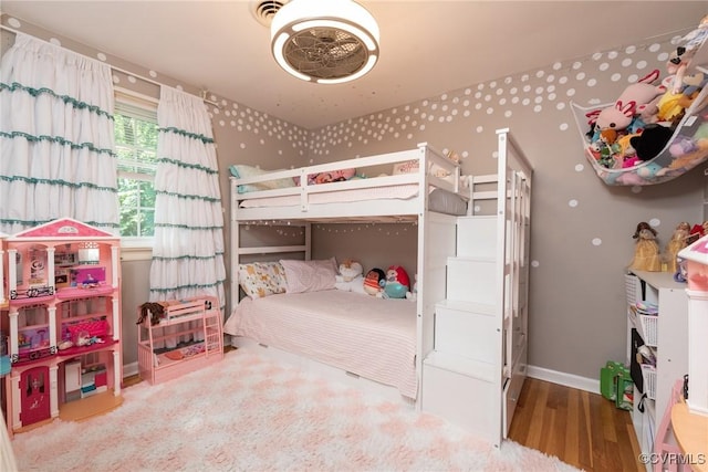 bedroom with wood finished floors and baseboards