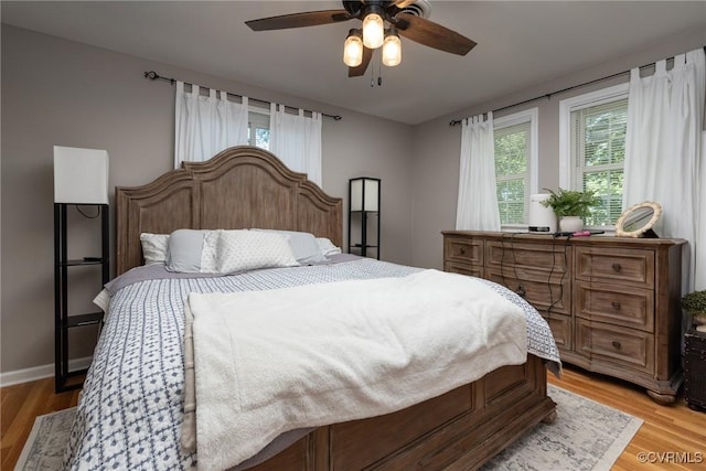 bedroom featuring light wood-style floors, ceiling fan, and baseboards