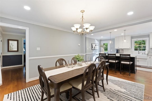 dining room featuring light wood-style floors, a chandelier, recessed lighting, and ornamental molding