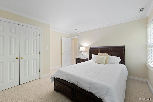 bedroom with carpet flooring, ornamental molding, baseboards, and a closet