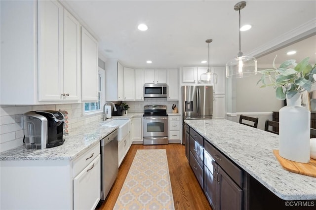 kitchen featuring stainless steel appliances, white cabinetry, dark wood-style flooring, a sink, and tasteful backsplash