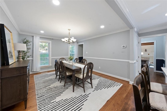 dining room featuring wood finished floors, a chandelier, recessed lighting, crown molding, and baseboards