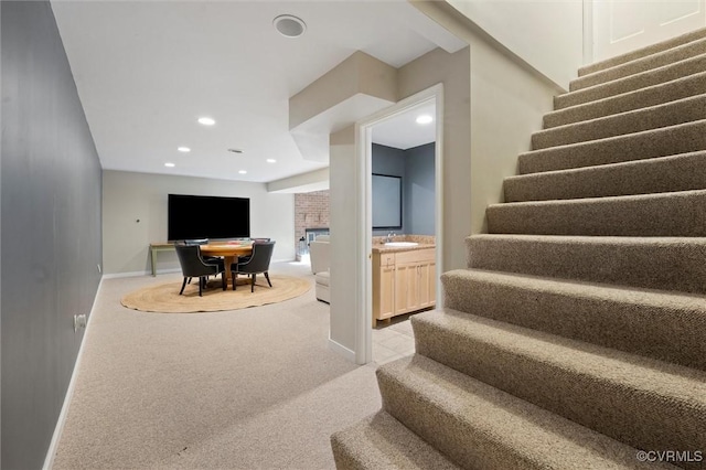 stairway with a fireplace, carpet floors, baseboards, and recessed lighting