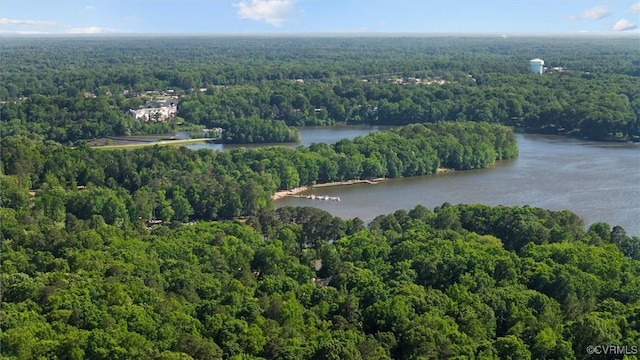 aerial view of property and surrounding area featuring a forest and a large body of water