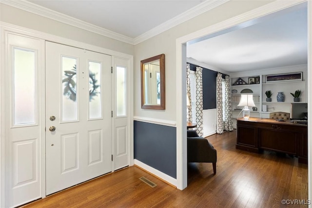 foyer with wood finished floors, ornamental molding, and healthy amount of natural light