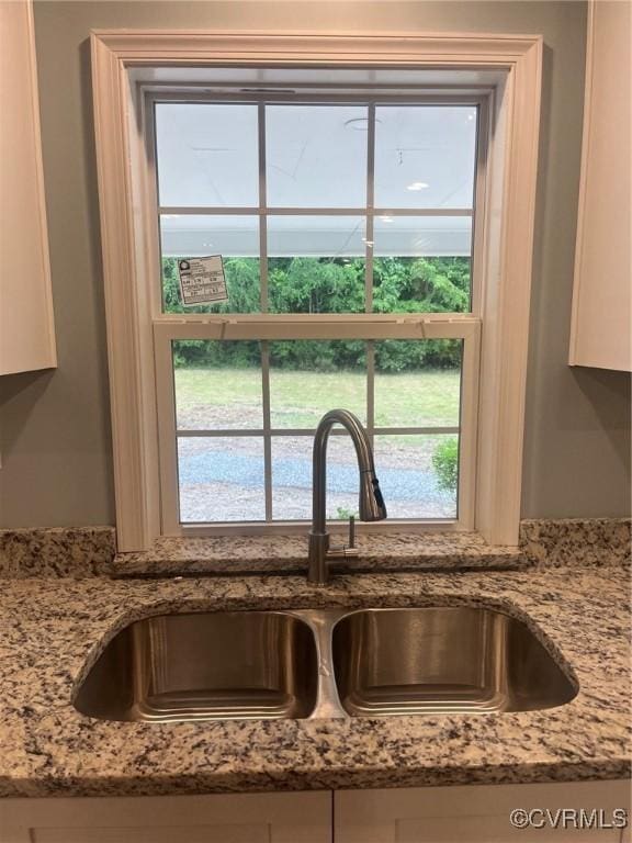 2720 Brunswick Rd, Emporia, VA 23847 - kitchen view of a sink, light stone counters, and white cabinetry